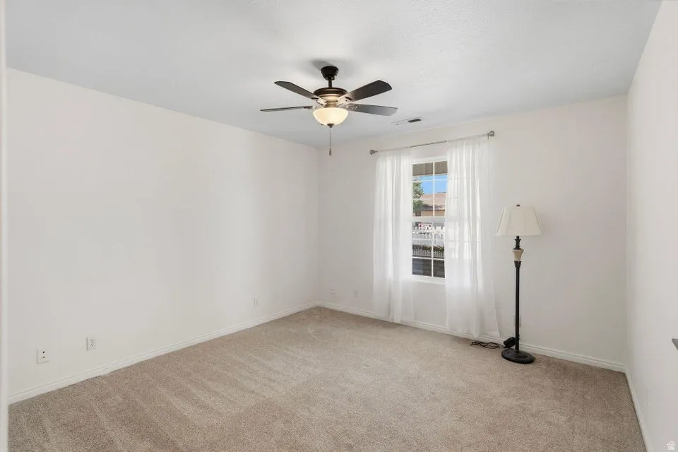 Empty room with carpet and ceiling fan