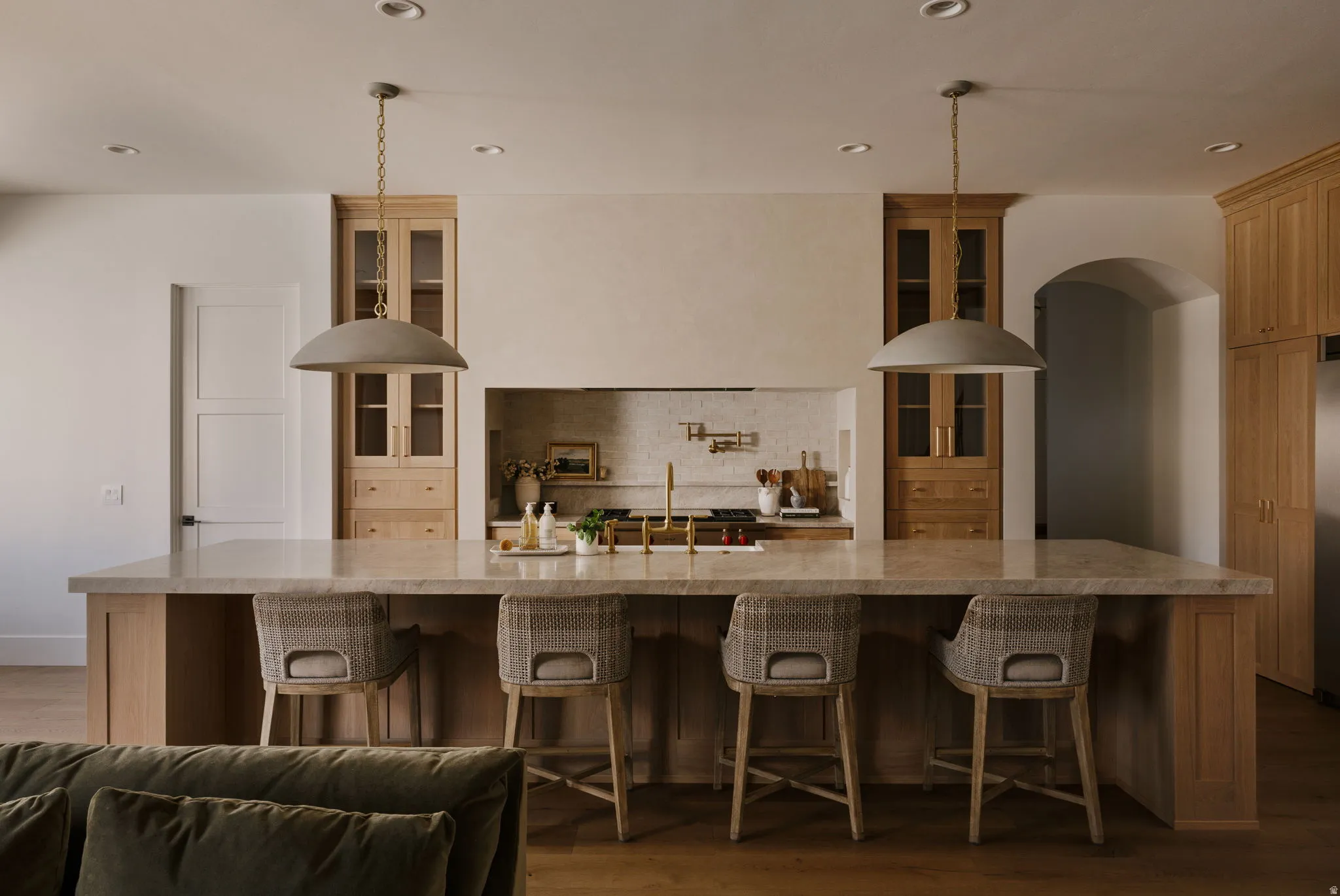 Kitchen with a breakfast bar area, glass insert cabinets, dark wood finished floors, and recessed lighting