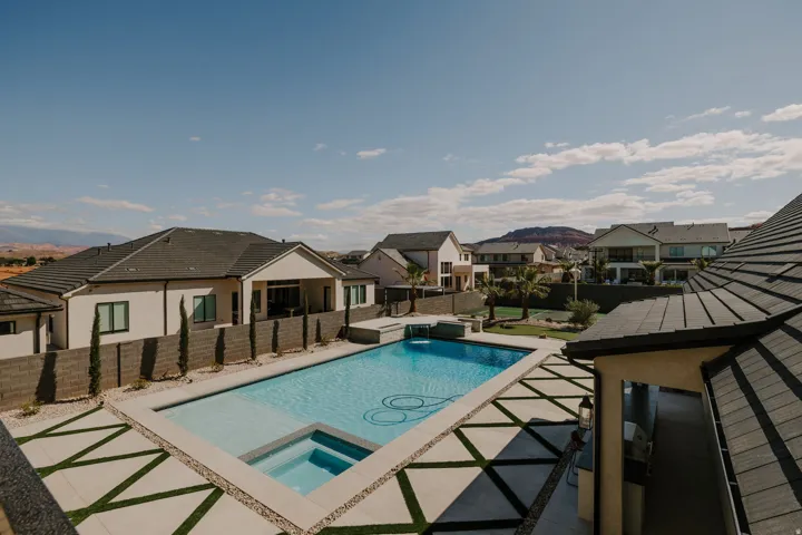 Relaxing pool / spa with a residential view, a patio, and a fenced backyard