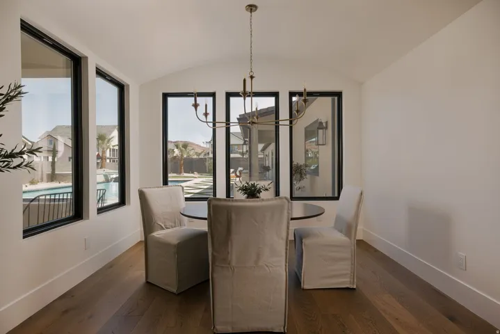 Dining space featuring suspended lighting, wood-type flooring, a barrel ceiling, and healthy amount of natural light