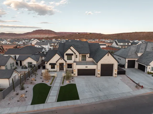 View of front of property with a residential view, driveway, stone siding, stucco siding, and a mountain view