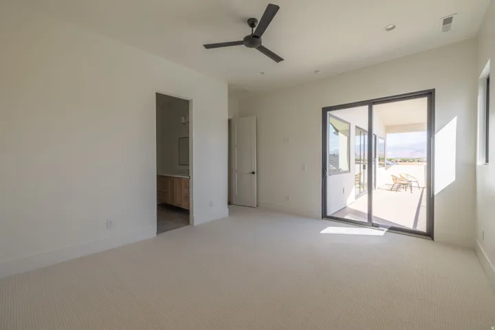 Unfurnished bedroom featuring light carpet, access to outside, ensuite bathroom, ceiling fan, and recessed lighting