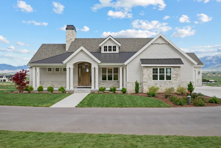 View of front facade featuring a mountain view, a standing seam roof, and a front lawn