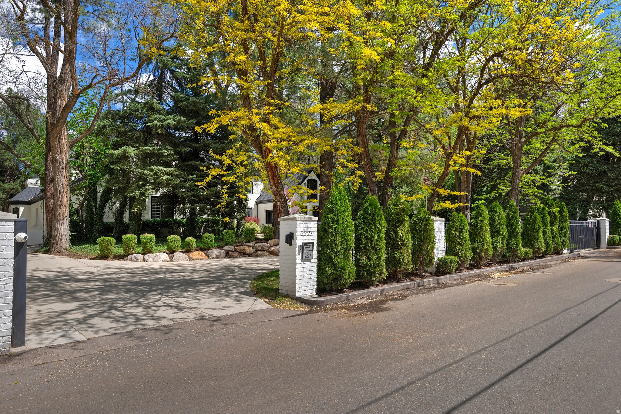 View of front facade, gates and treelined street