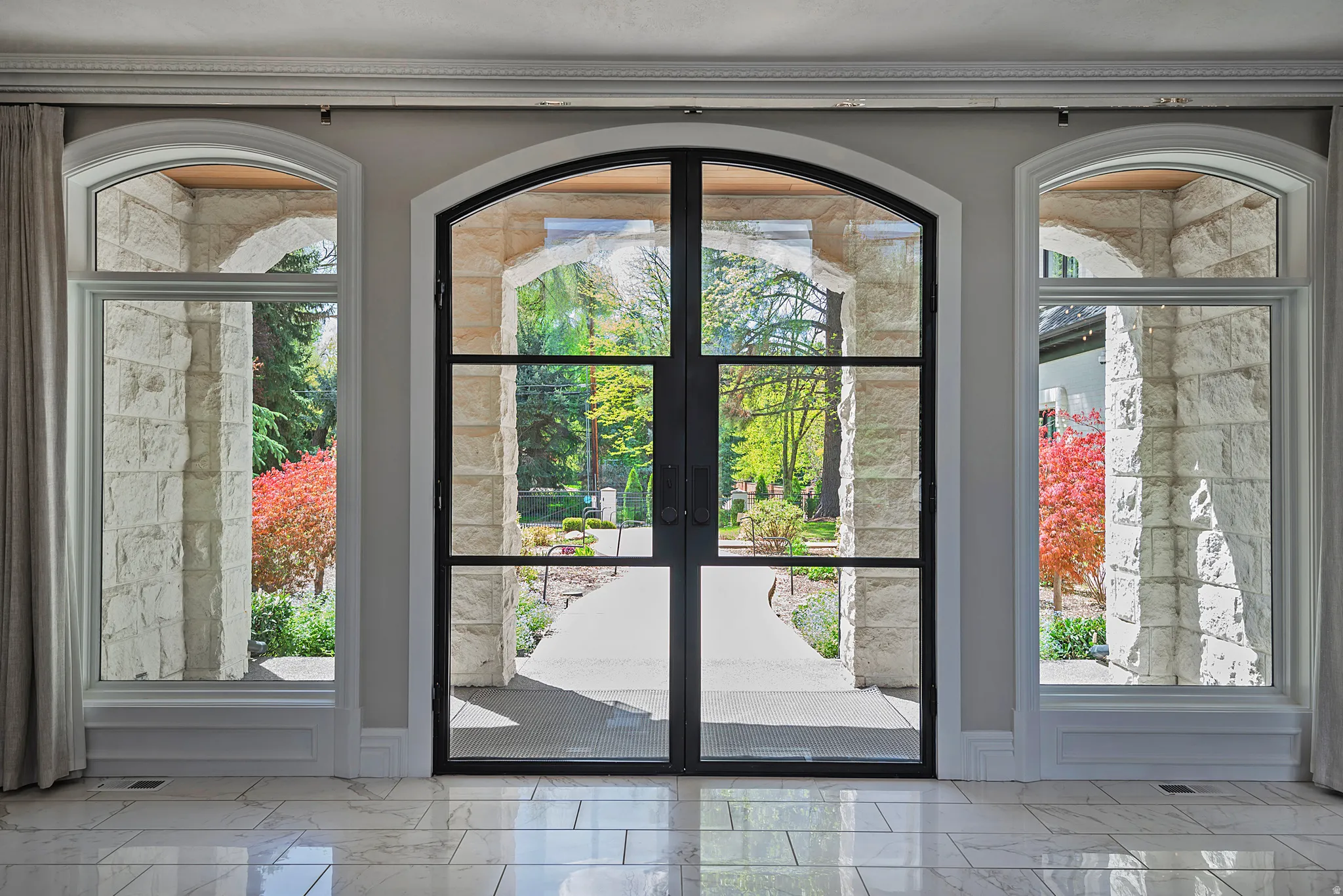 Entryway with french doors and marble tile flooring - bringing the outside in.