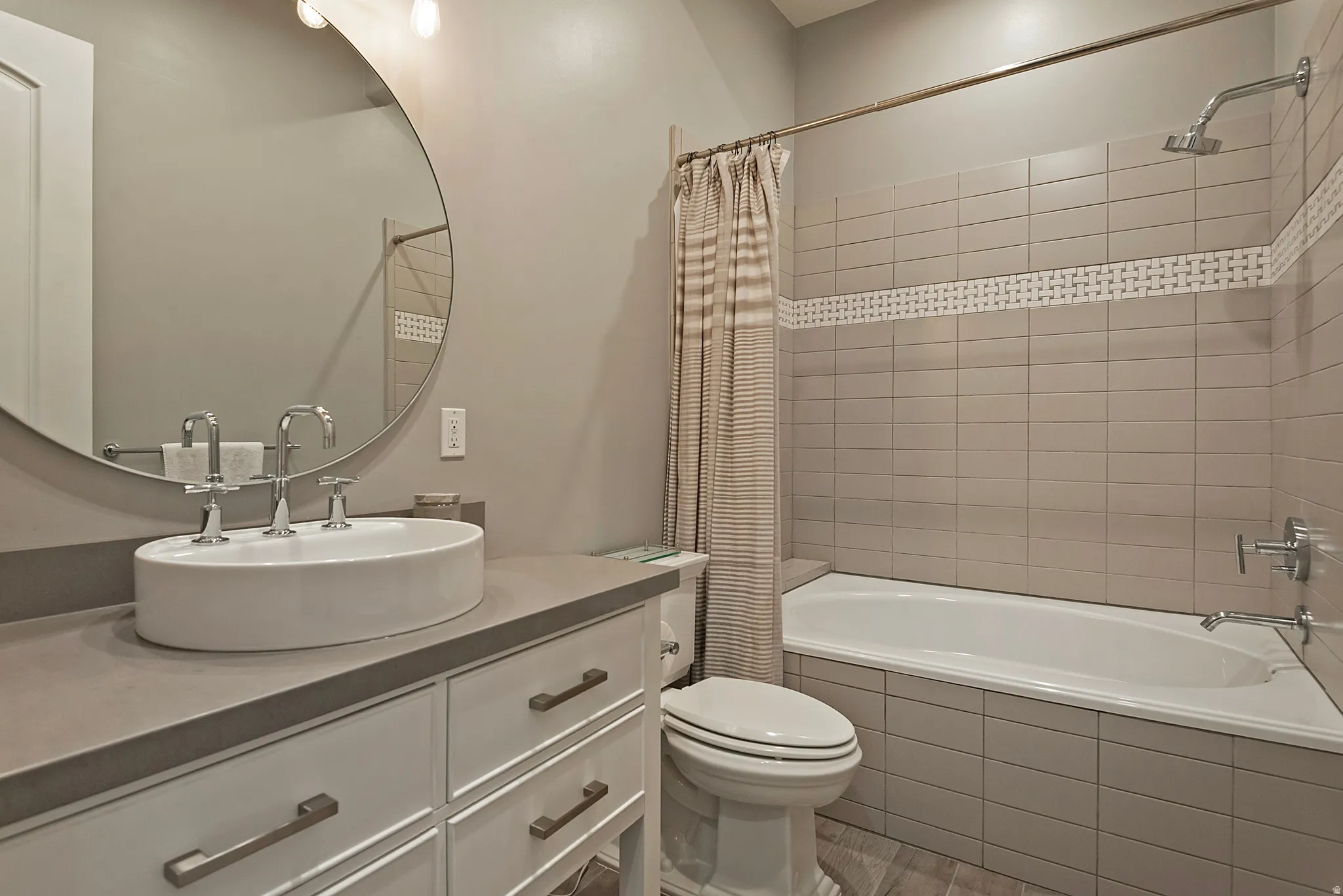 Bathroom featuring vanity, tiled shower / bath, and light wood-style flooring