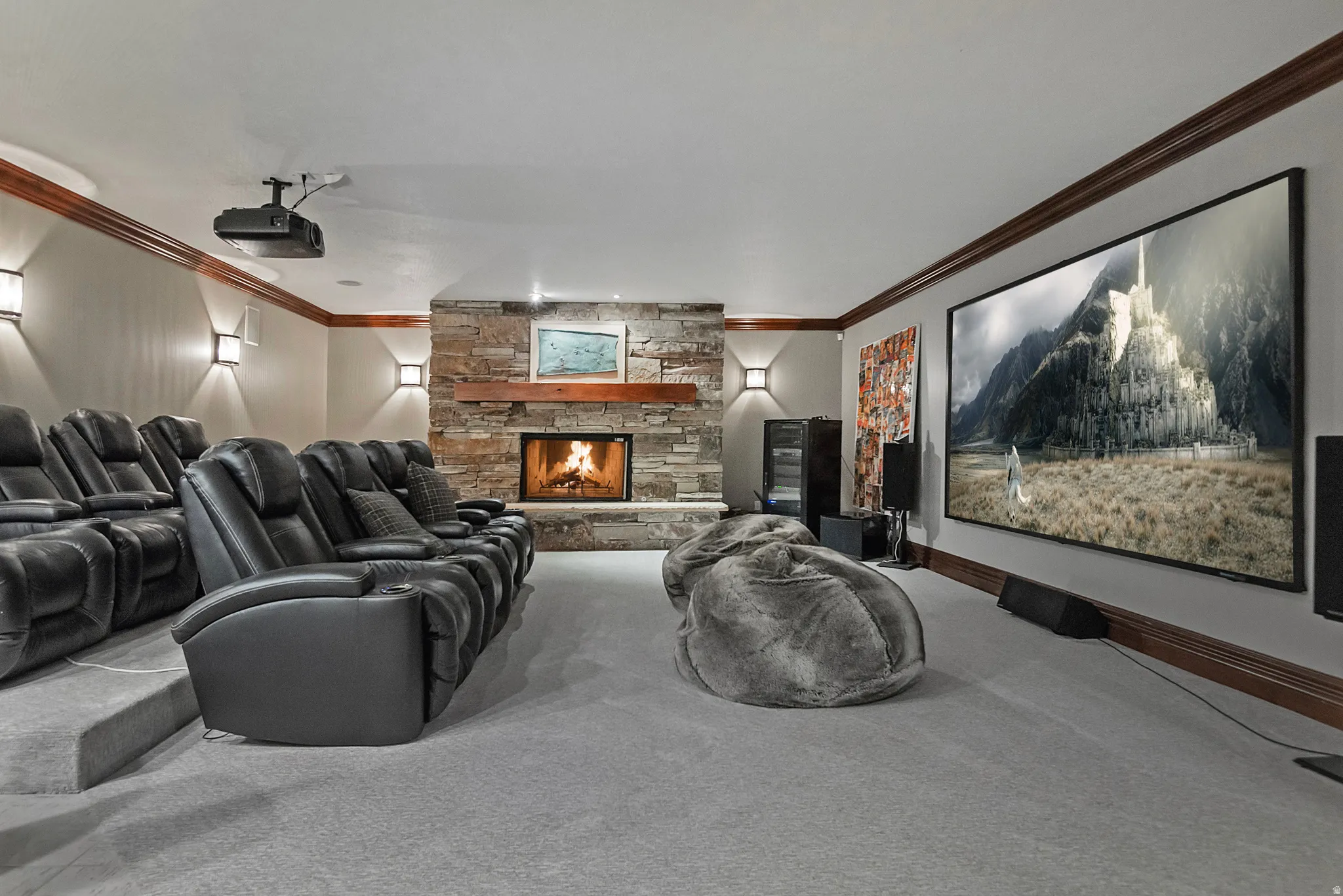 Beautiful home theater room featuring a fireplace, wet bar with tons of cabinetry and room for a crowd