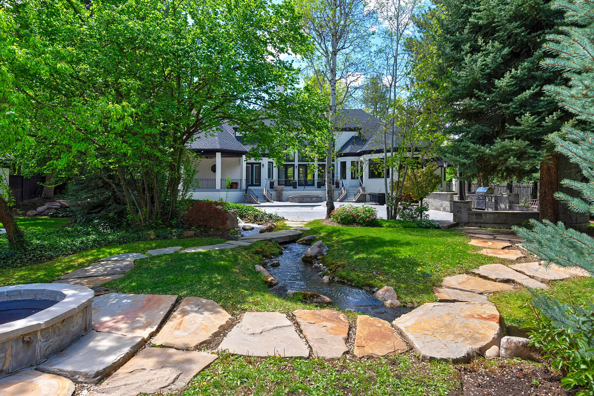 Back of house featuring a garden pond, a patio, meandering paths and fire pit