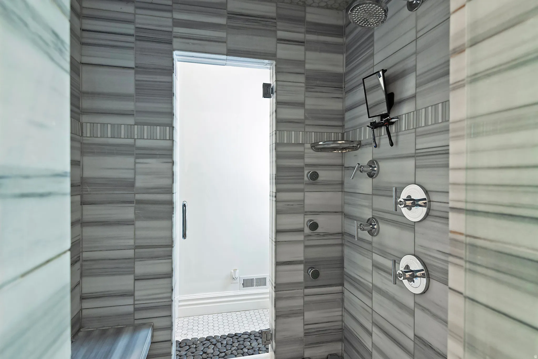 Spa inspired shower with multiple shower heads.