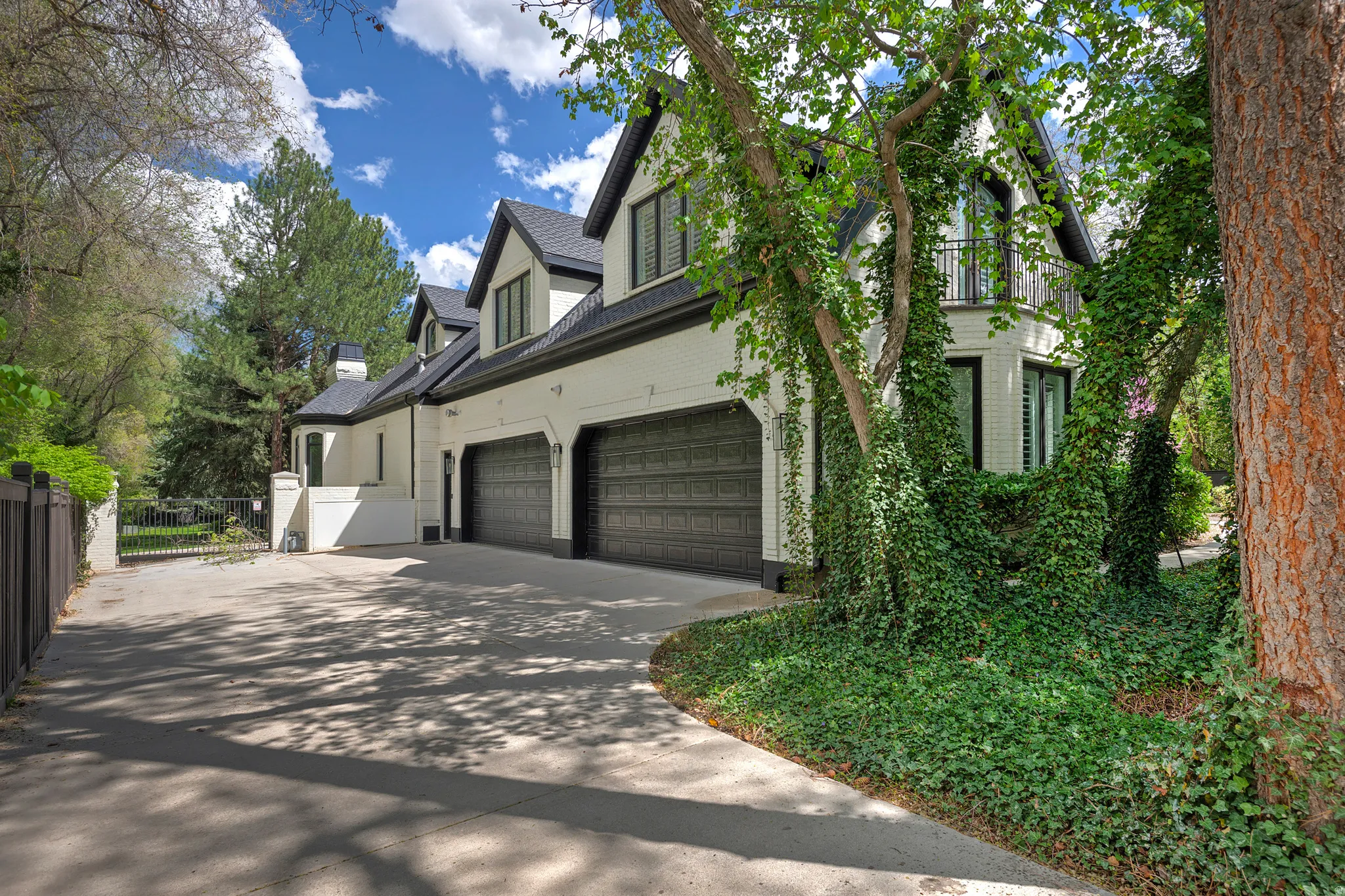 View of home's exterior featuring concrete driveway, a 4 car garage, and a gate