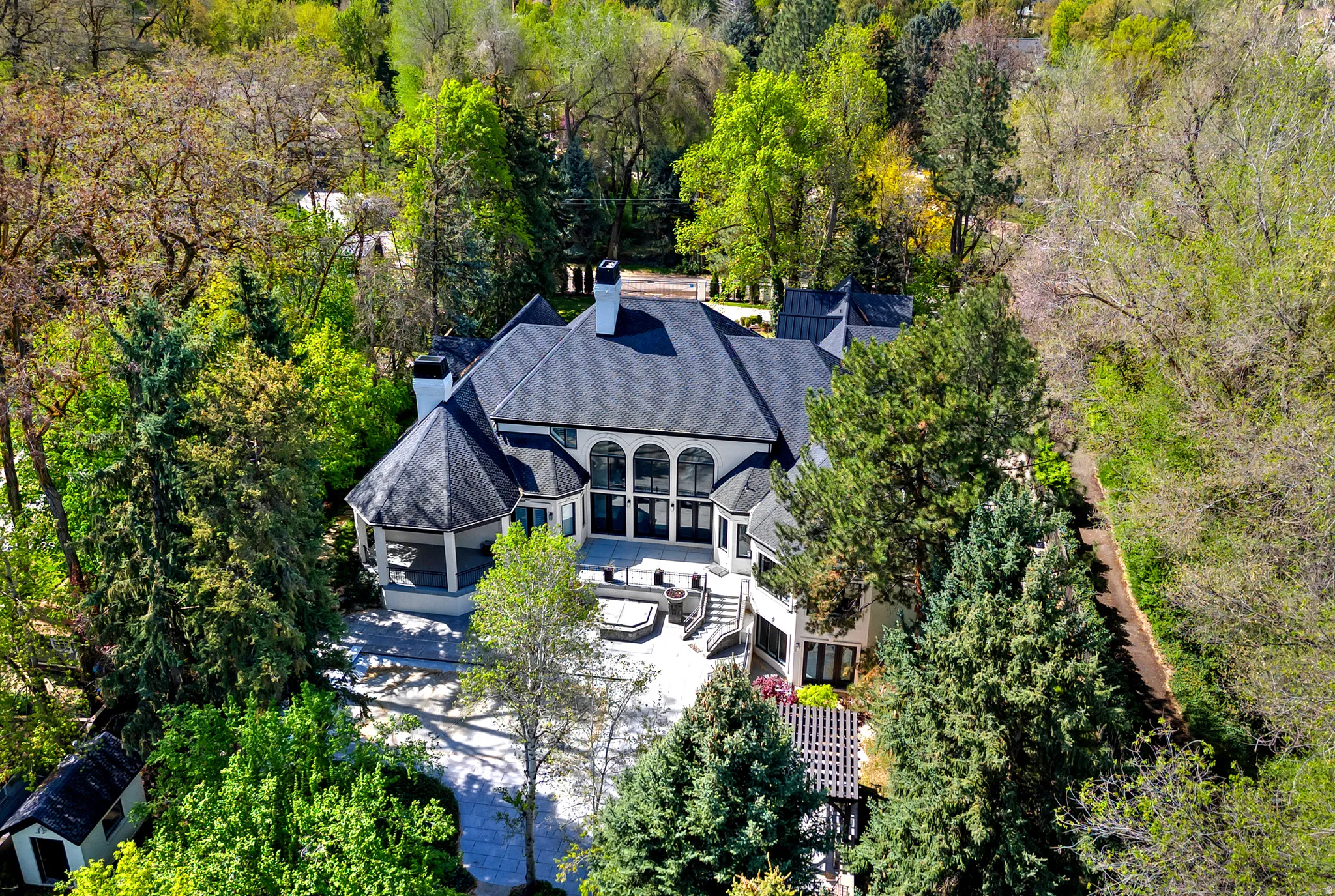 Aerial view of property and surrounding area featuring a tree filled landscape