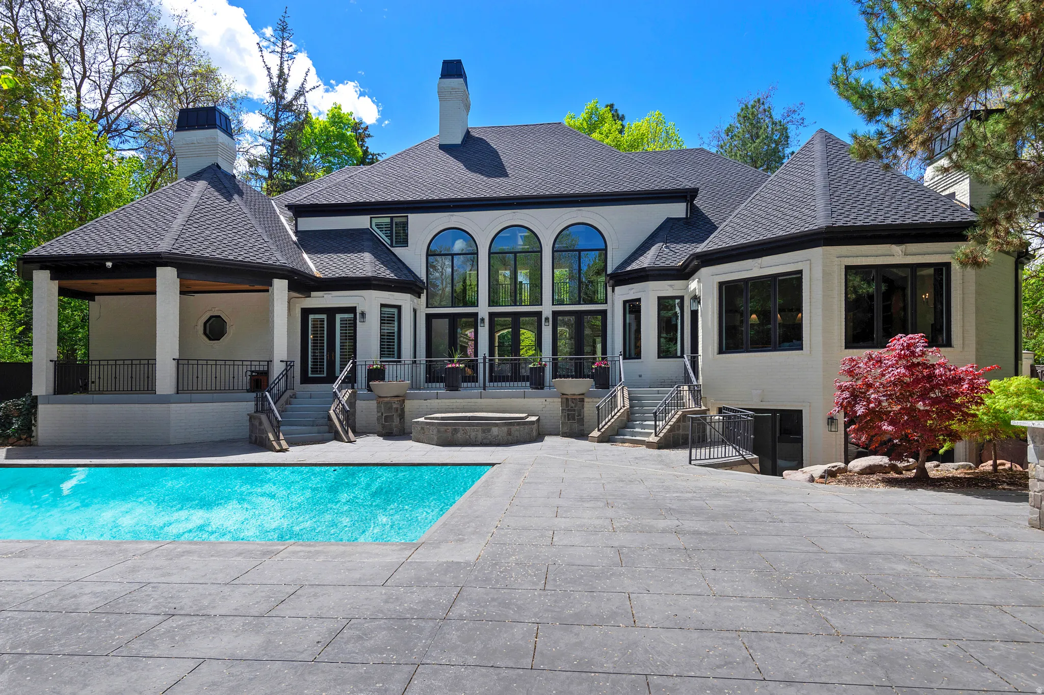 Back of house with a patio area, an outdoor pool, a chimney, french doors, and stucco siding