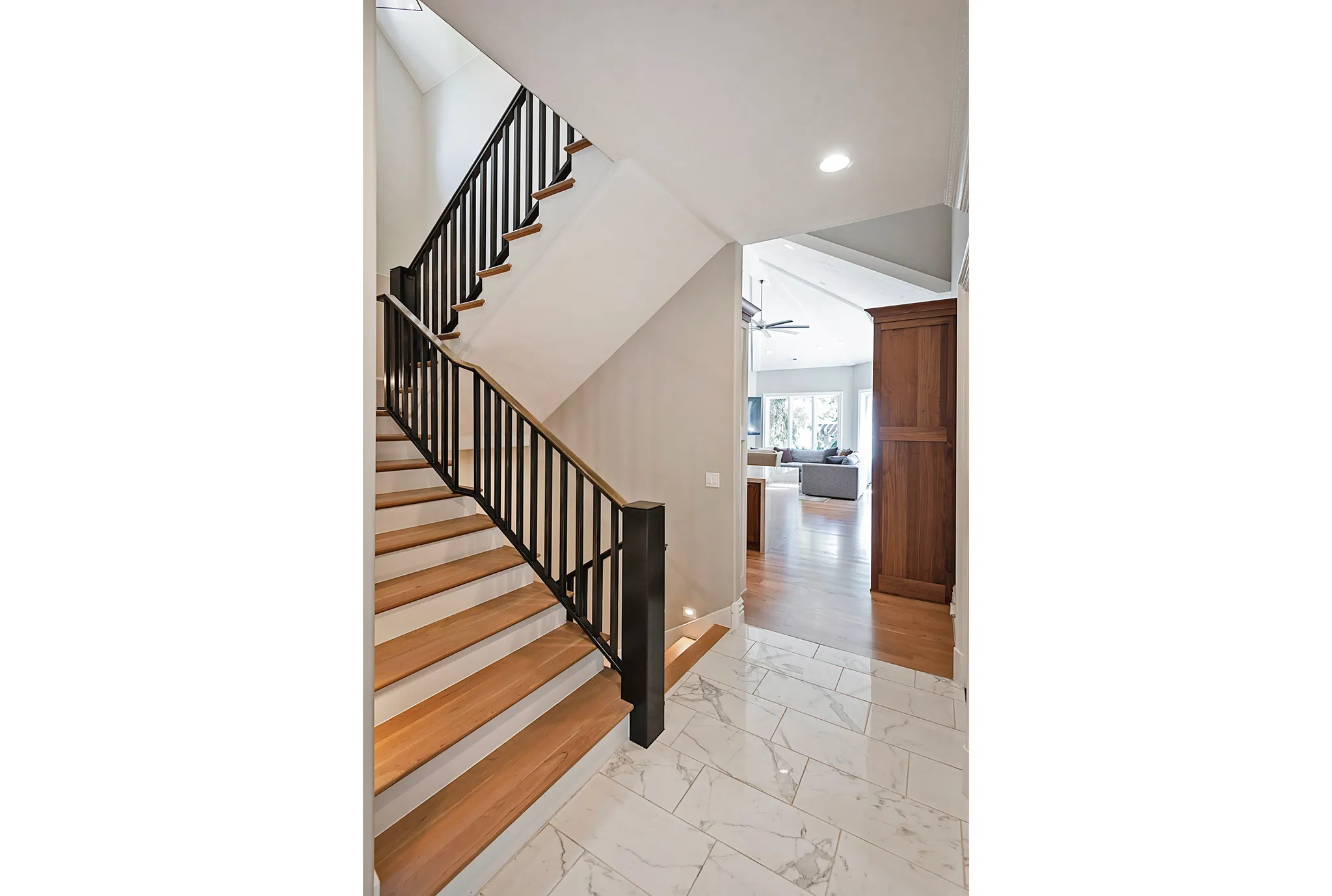 Custom iron Staircase featuring marble tiles and wood treads