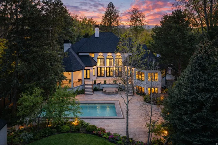 Back of house with a spa, pool, huge .91ac yard, decks and patios, in ground trampoline, basketball court and more!