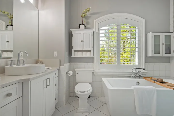 Bathroom with vanity, wainscoting, a soaking tub, light tile patterned flooring, tile walls, and glass shower