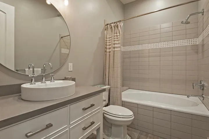 Bathroom featuring vanity, tiled shower / bath, and light wood-style flooring