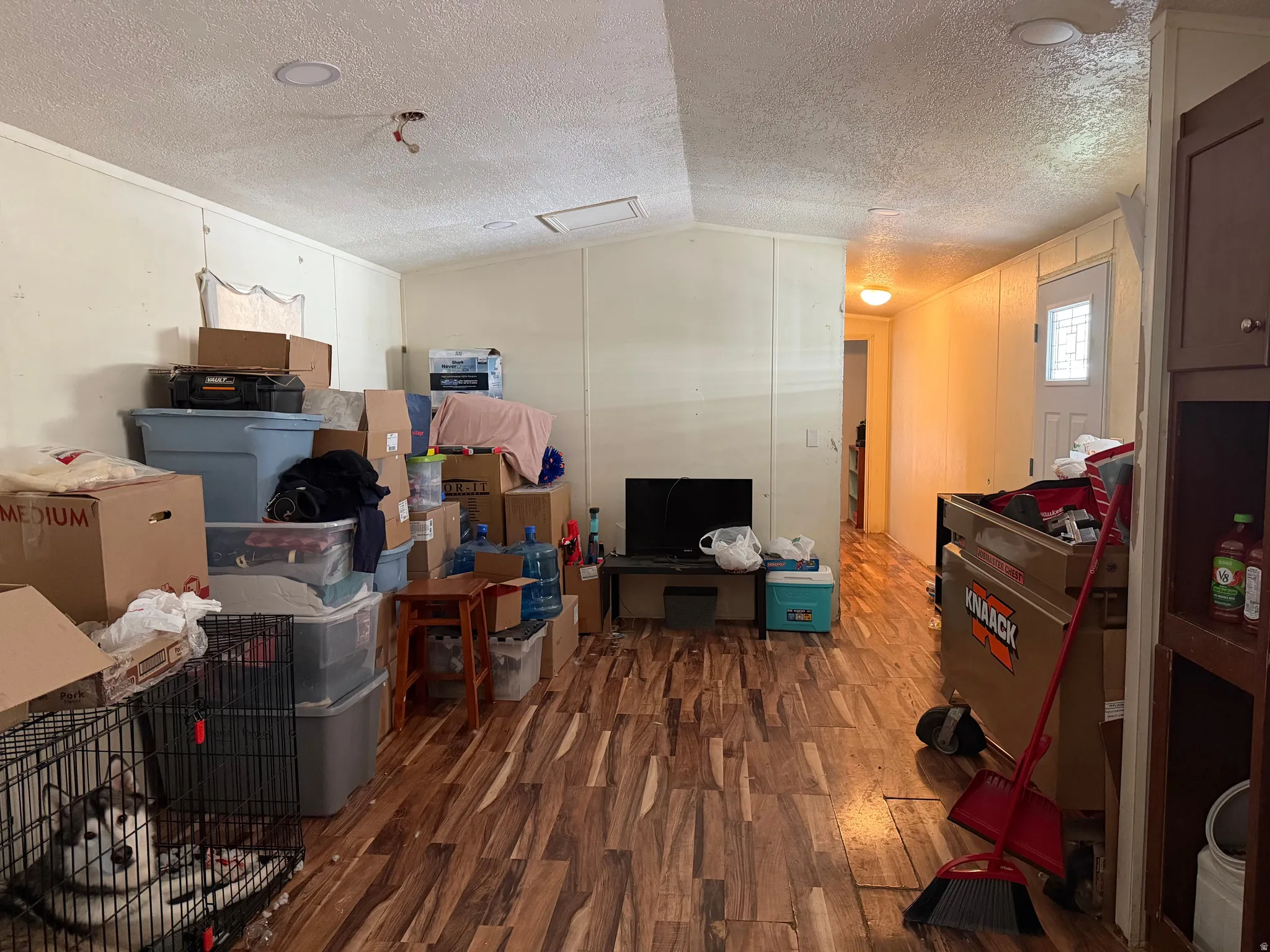 Below grade area with dark wood-type flooring and a textured ceiling