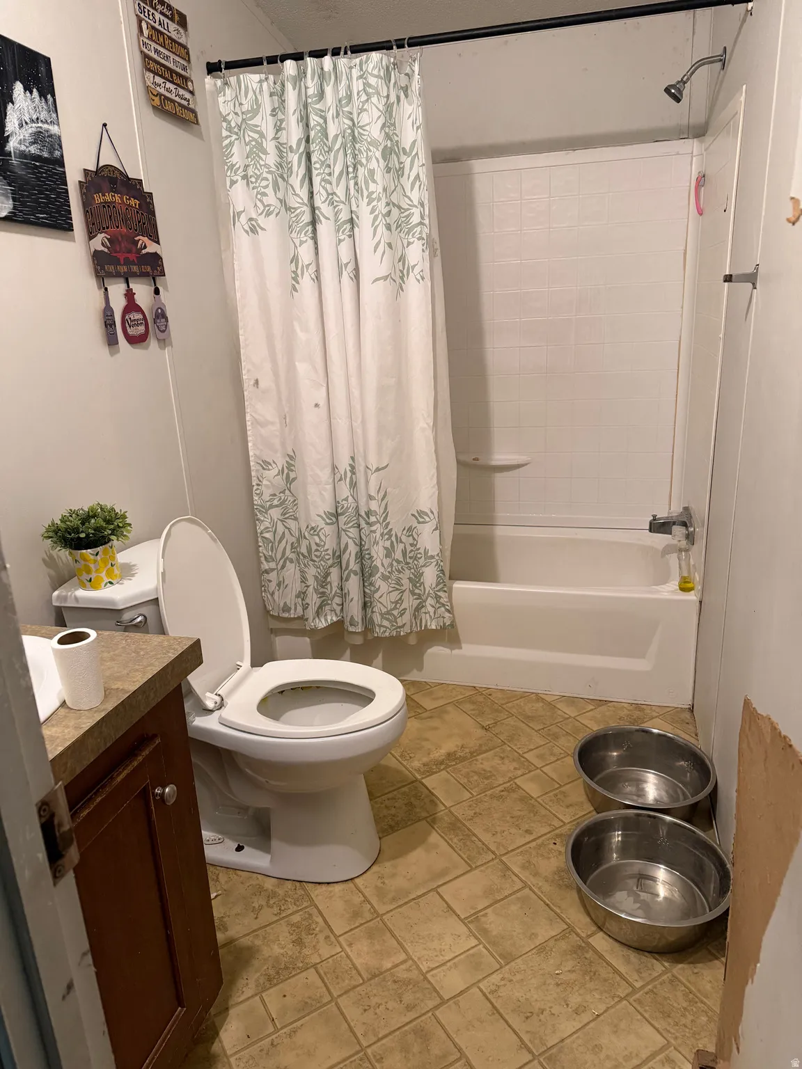 Bathroom with vanity, shower / bath combination with curtain, and light stone finish flooring