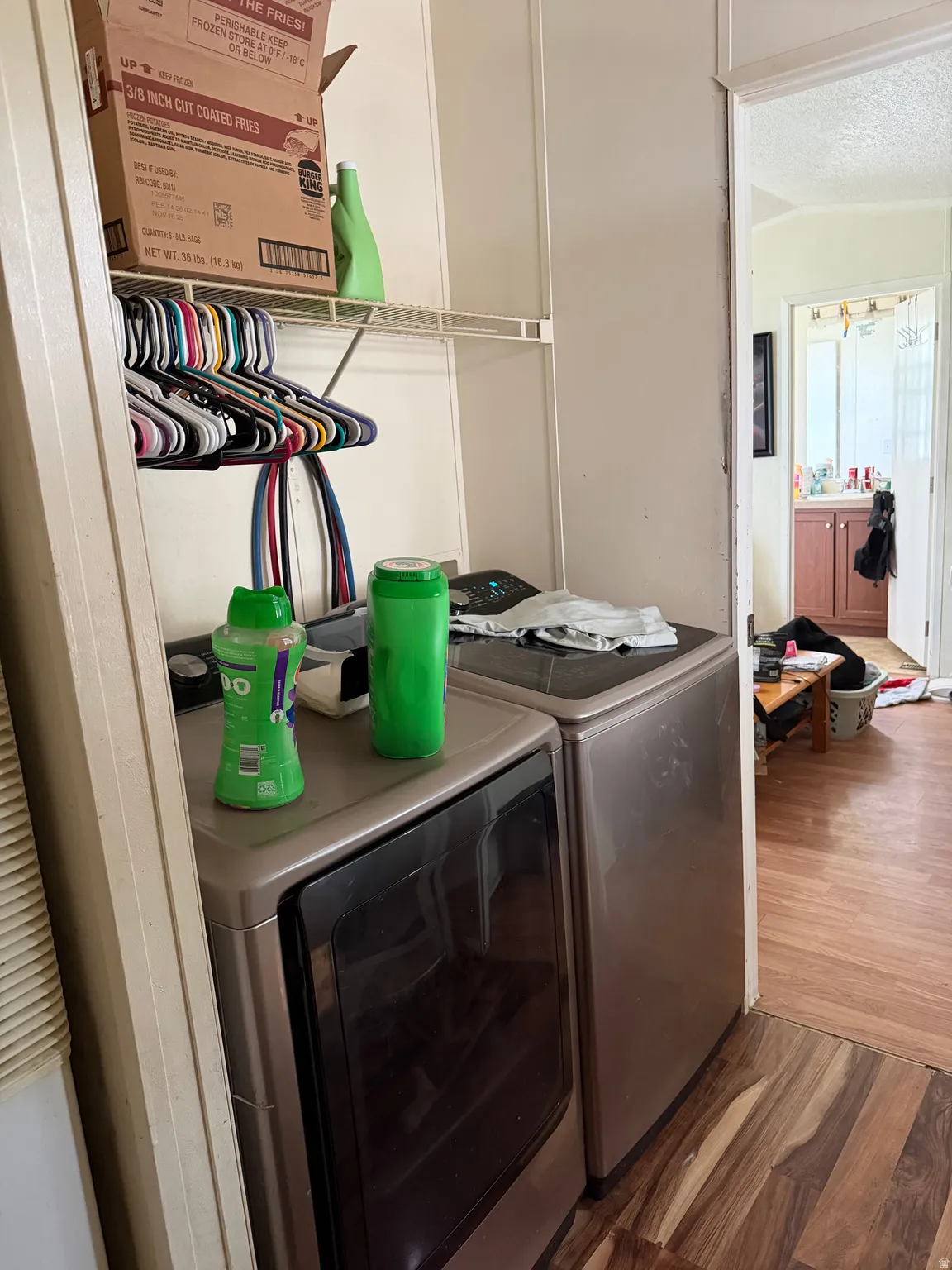 Laundry area with dark wood-type flooring, independent washer and dryer, and a textured ceiling