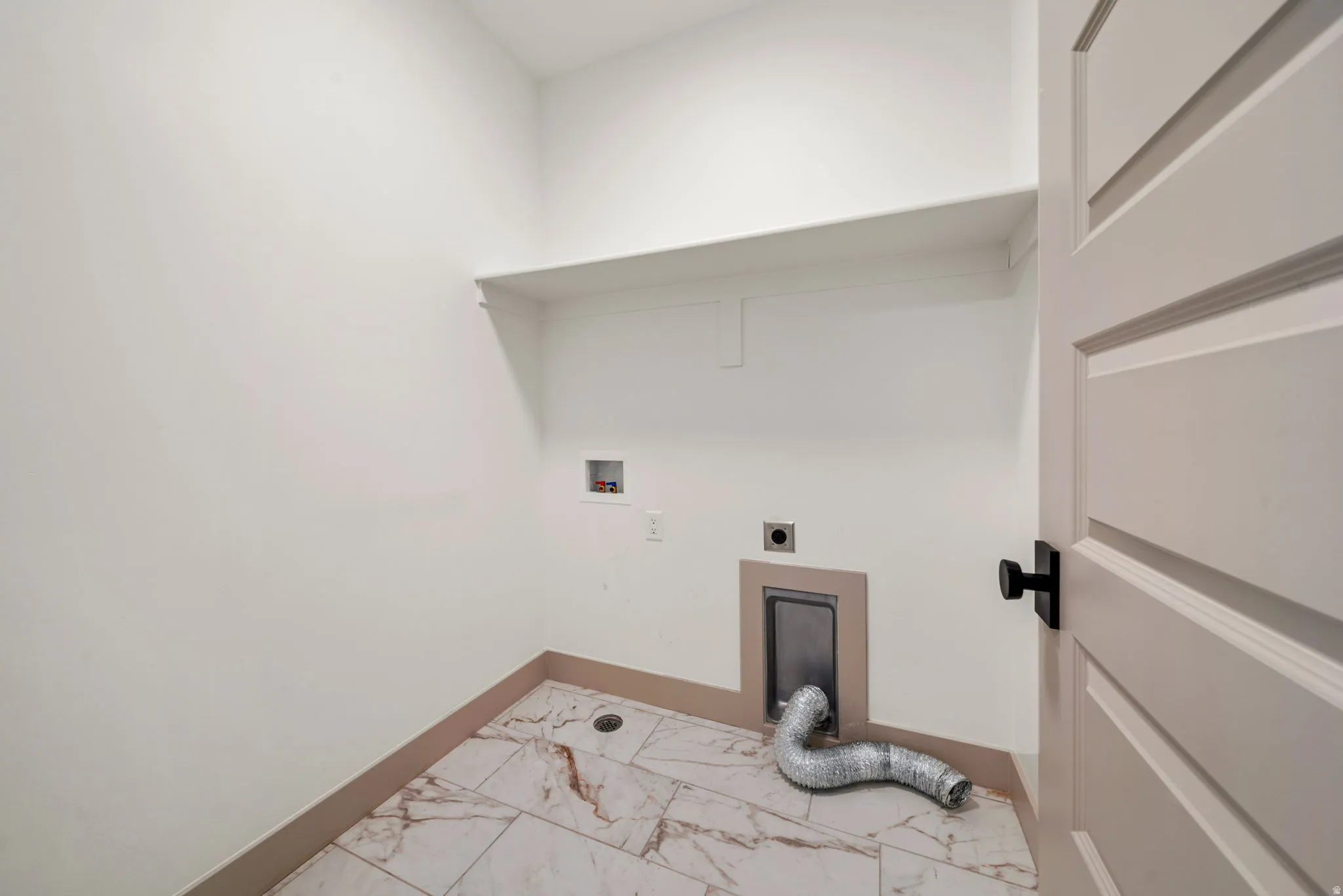 Laundry room featuring hookup for an electric dryer, light marble finish flooring, and hookup for a washing machine