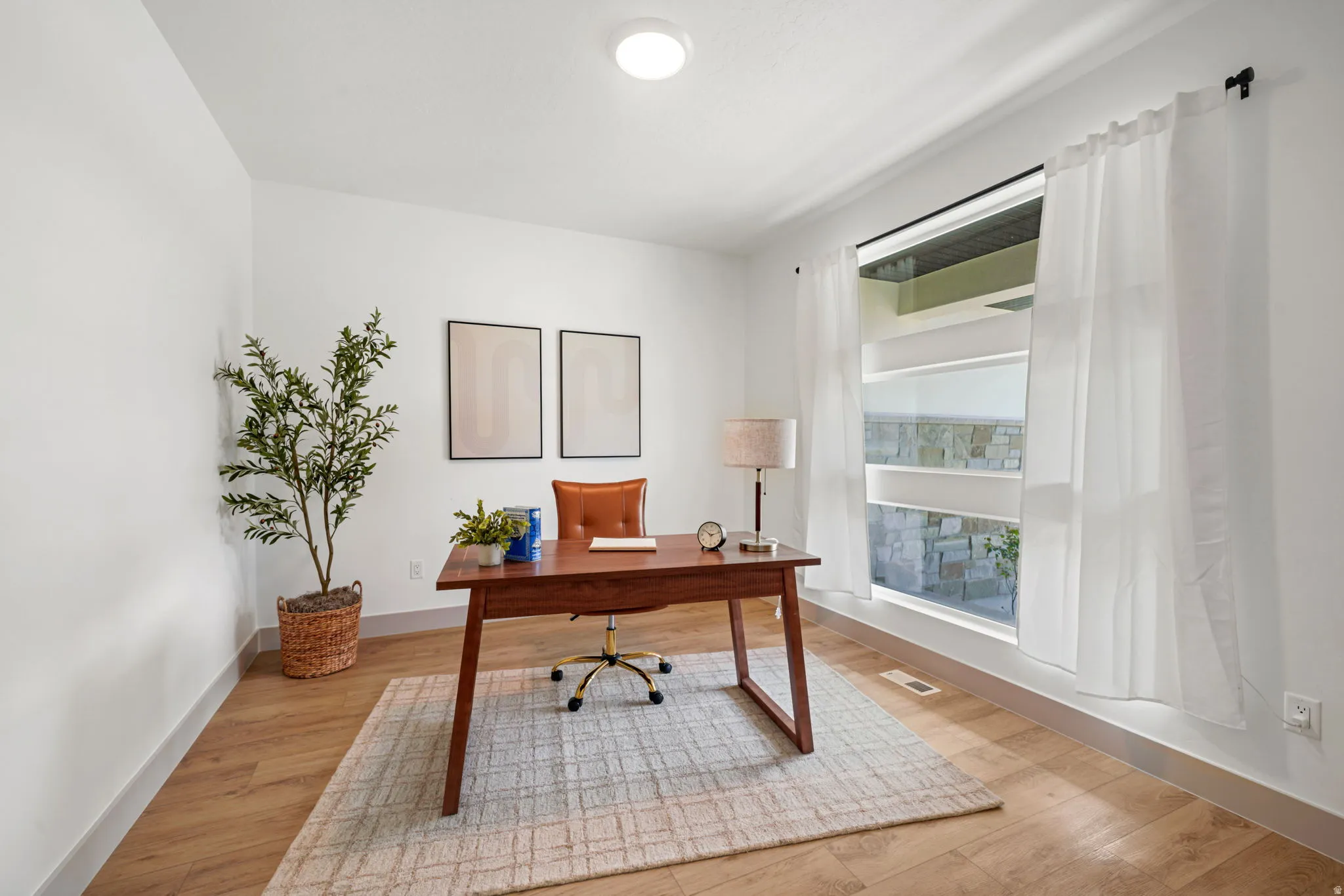 Office with baseboards and light wood-style flooring