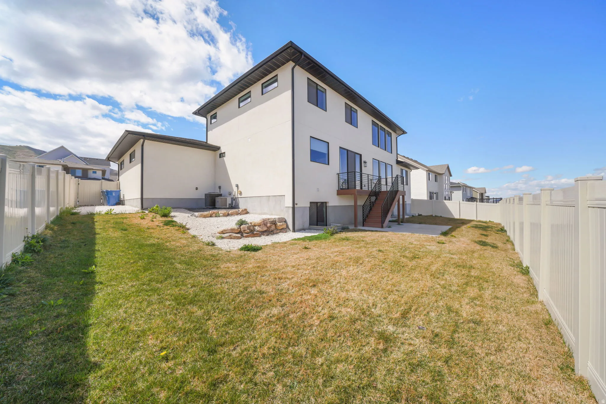 Rear view of property featuring a fenced backyard, a patio, and stucco siding
