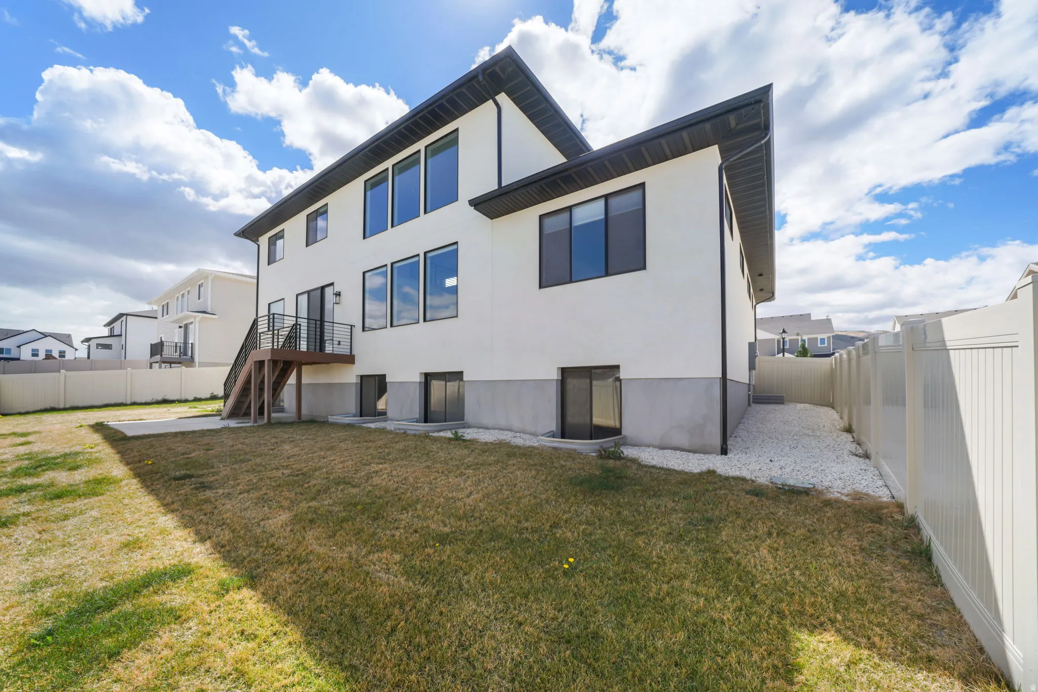Back of house featuring a fenced backyard, a patio, and stucco siding