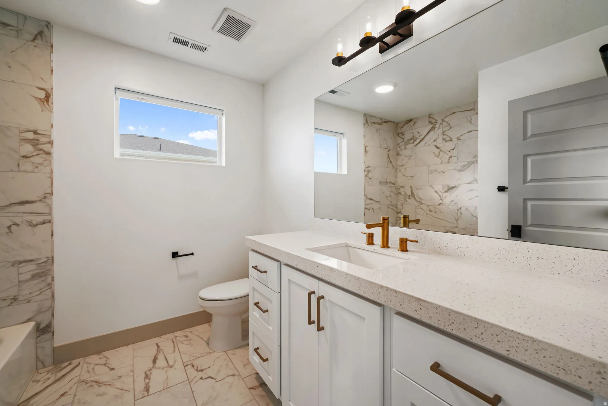Bathroom with vanity and light marble finish floors