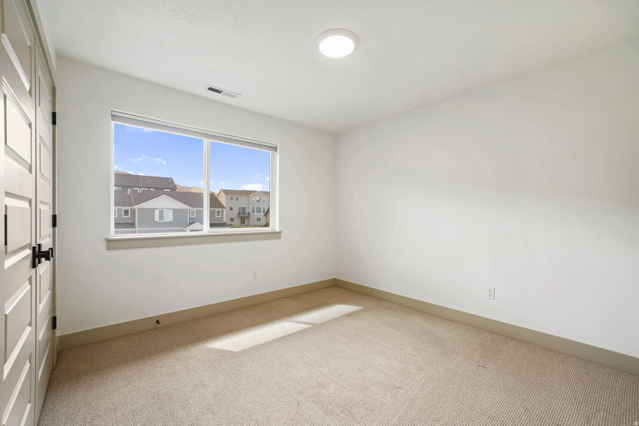 Unfurnished bedroom featuring light carpet and a closet