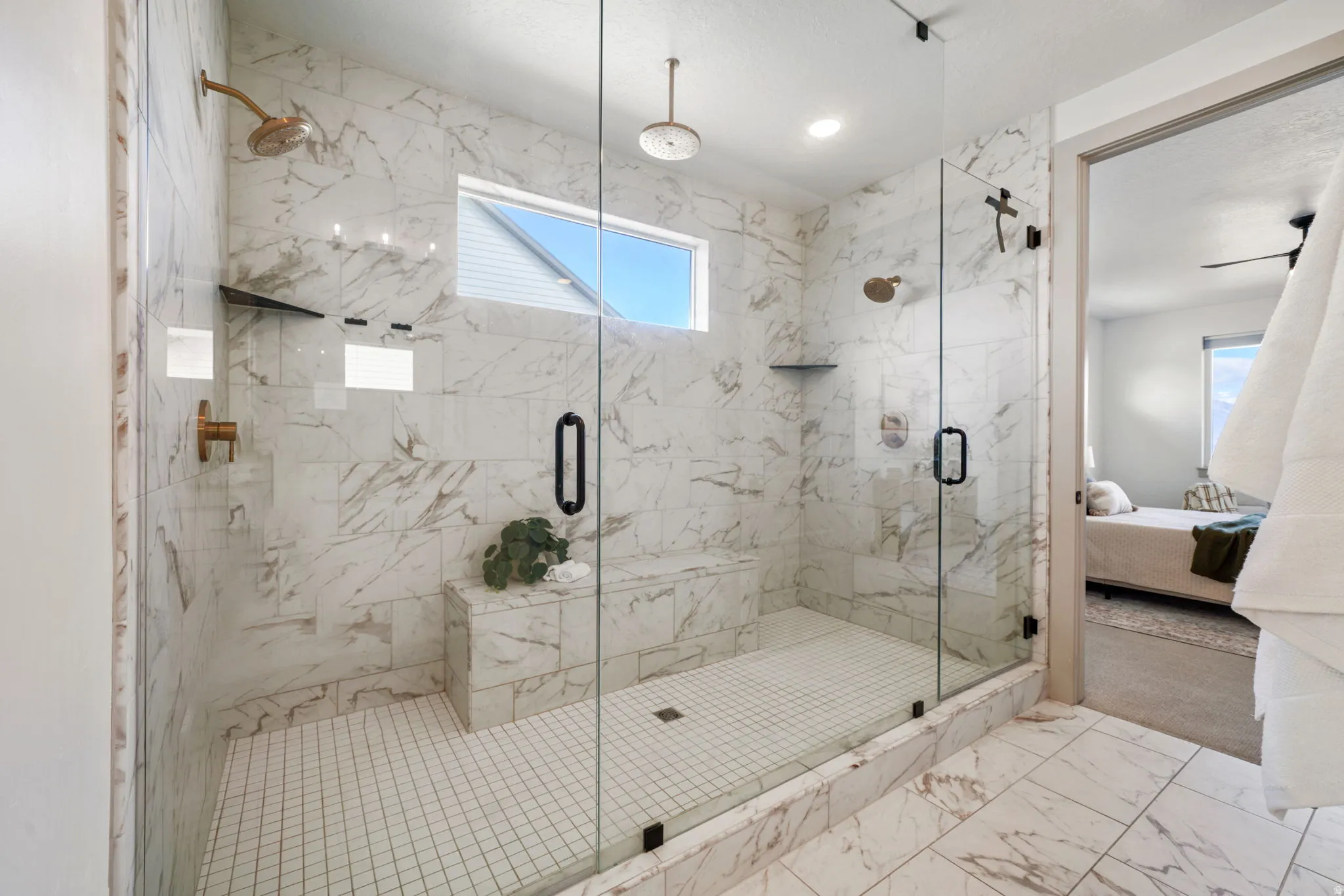 Ensuite bathroom with a marble finish shower and light marble finish flooring