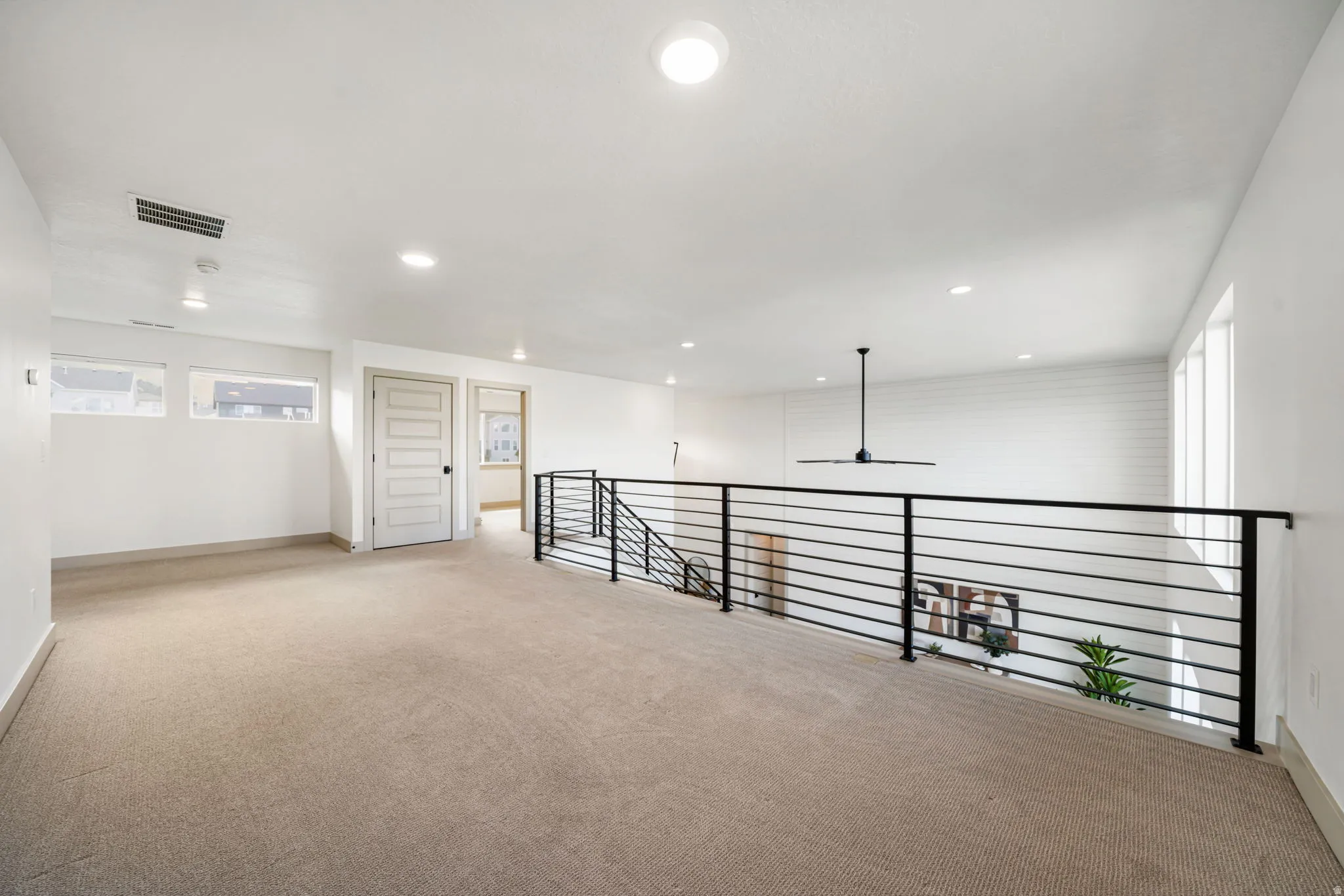Spare room with light colored carpet, ceiling fan, and recessed lighting