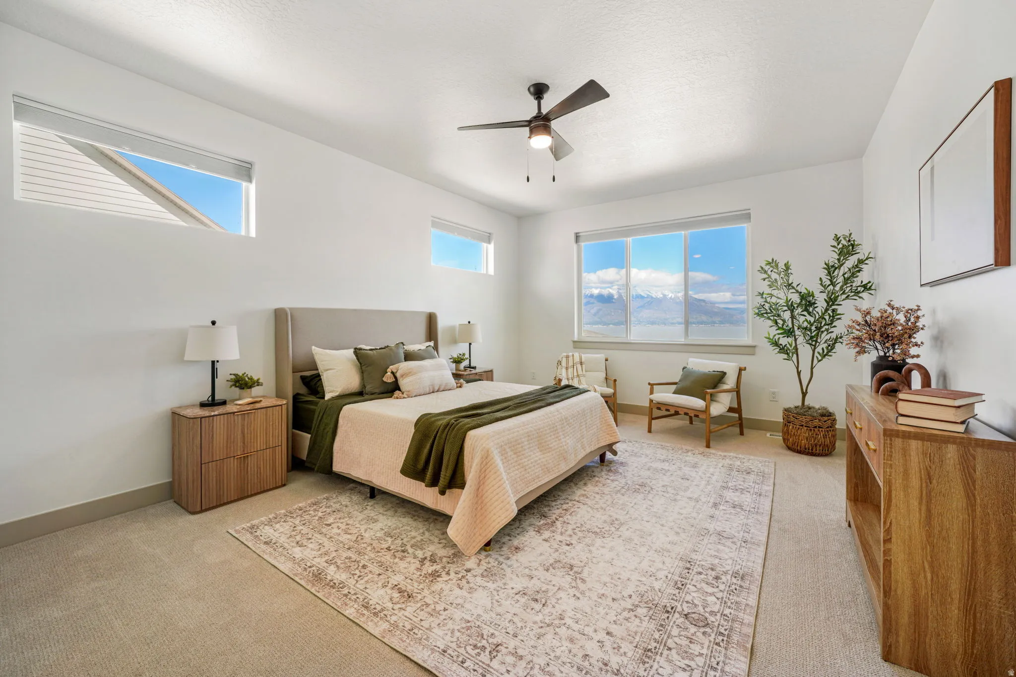 Bedroom featuring a ceiling fan, light carpet, and multiple windows