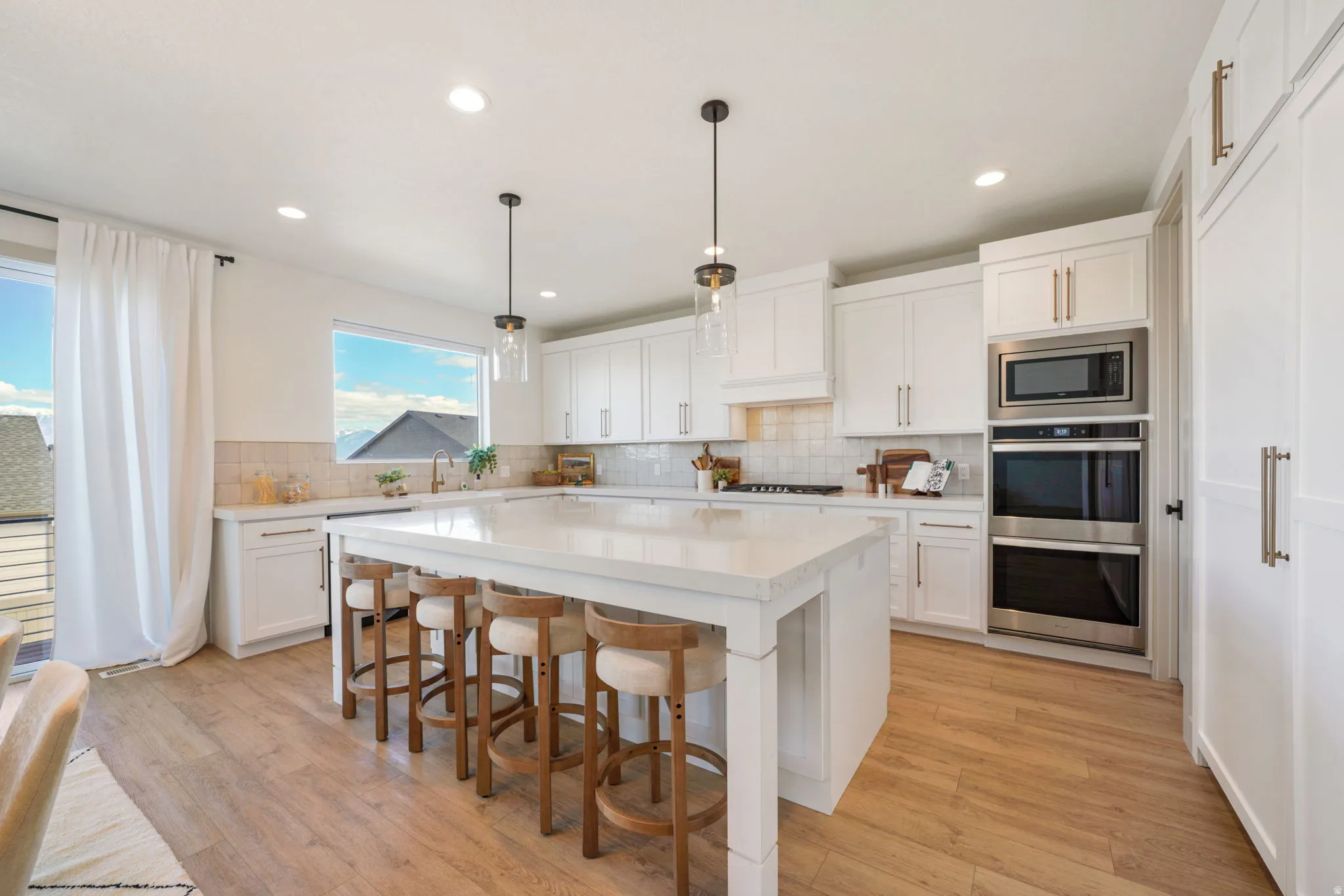 Kitchen with a kitchen bar, white cabinetry, and light wood finished floors