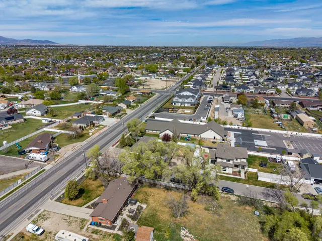 Aerial view of property and surrounding area with nearby suburban area and a mountainous background