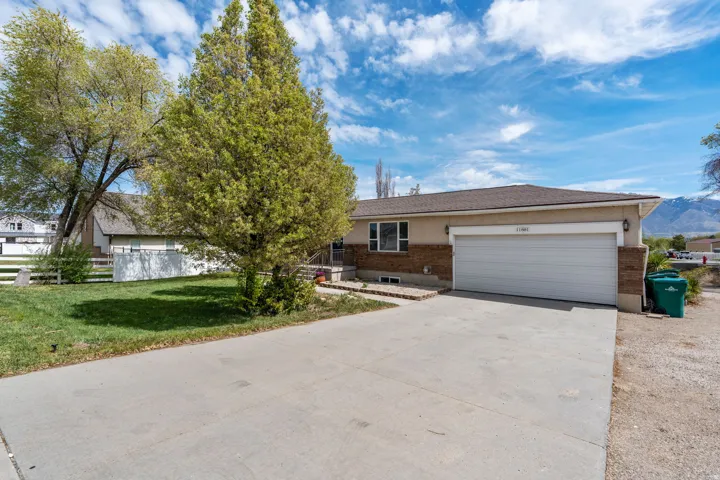 Single story home featuring an attached garage, driveway, and brick siding