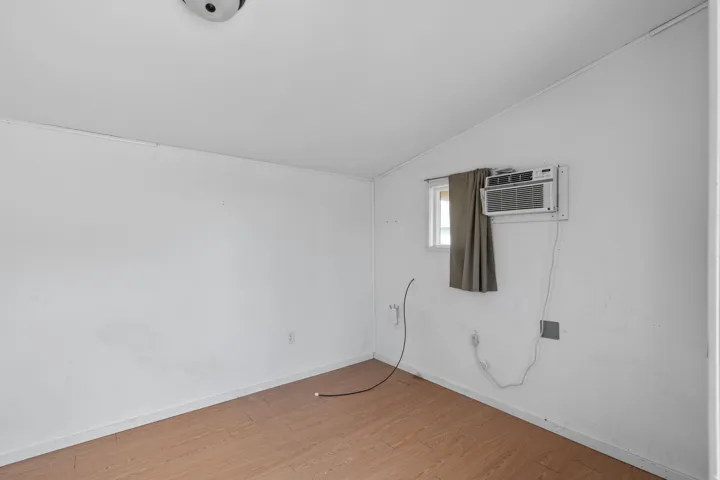 Spare room with vaulted ceiling and light wood-style floors