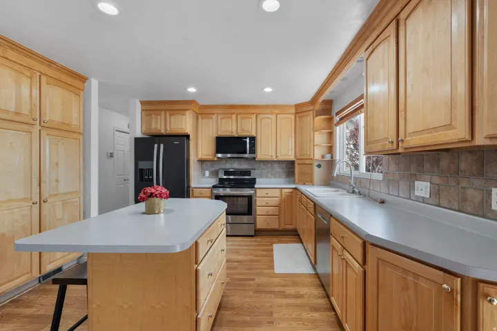 Kitchen featuring open shelves, stainless steel appliances, light wood-type flooring, tasteful backsplash, and recessed lighting