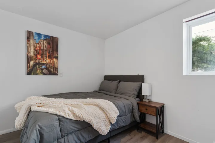 Bedroom with wood finished floors and baseboards