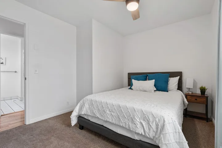 Carpeted bedroom featuring a ceiling fan and baseboards
