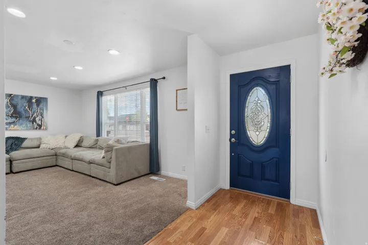 Entryway with light wood finished floors and recessed lighting