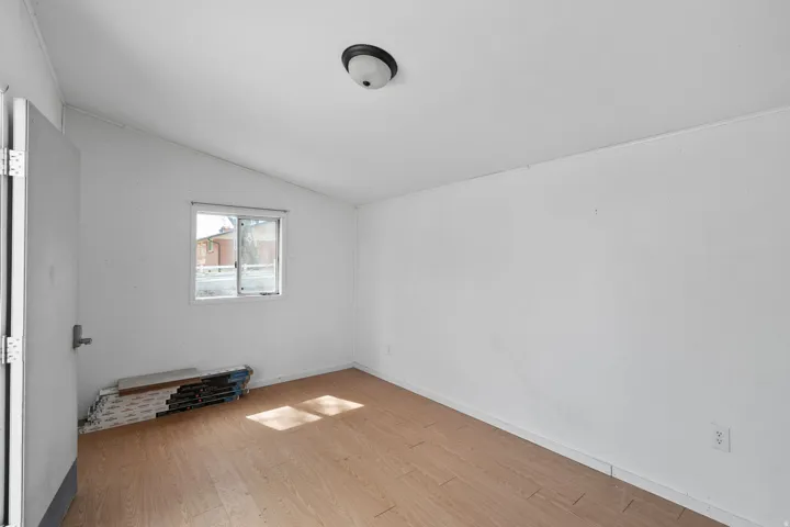 Unfurnished room with lofted ceiling and light wood-style floors