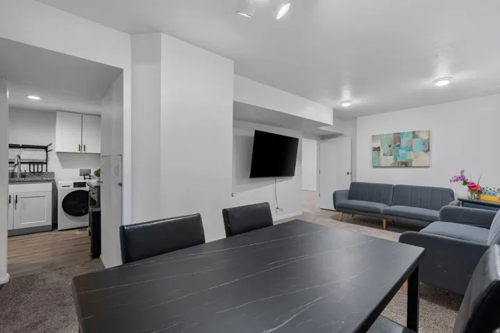 Recreation room with washer / clothes dryer and dark colored carpet