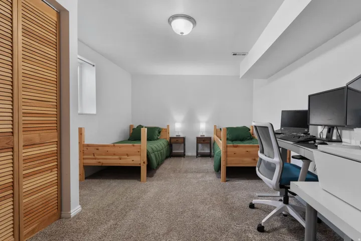 Bedroom with a desk and dark colored carpet