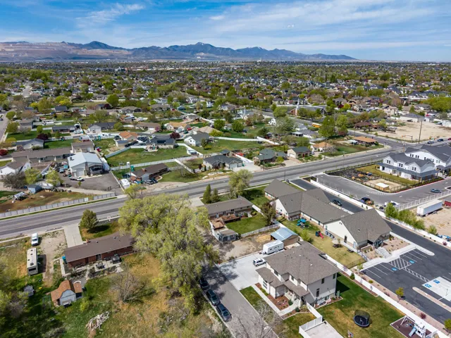 Aerial view of property and surrounding area with nearby suburban area and mountains