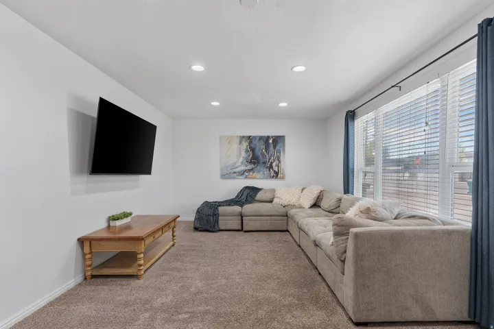 Carpeted living room featuring recessed lighting and baseboards