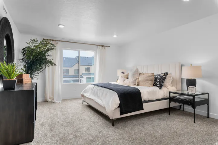 Bedroom featuring light carpet and baseboards