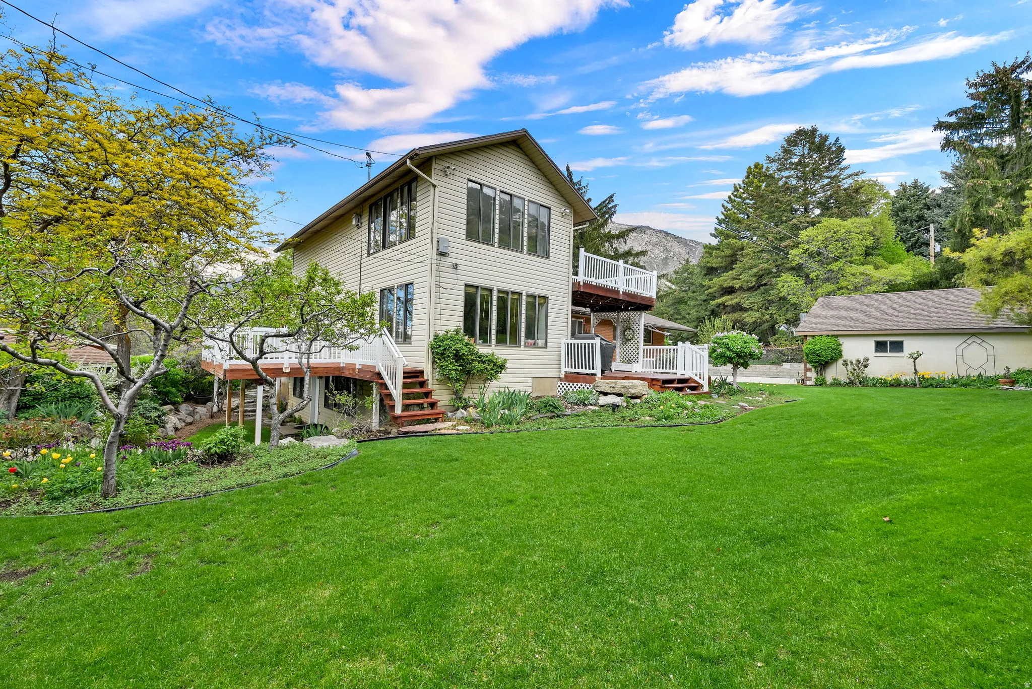 Rear view of house featuring a yard and a wooden deck