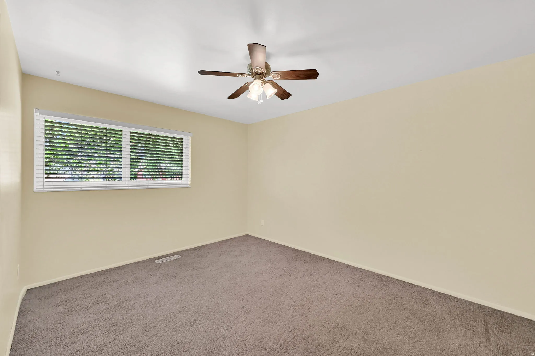 Spare room with dark colored carpet and a ceiling fan
