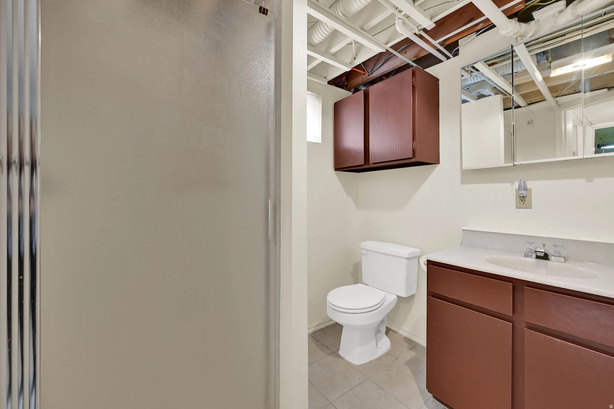 Bathroom featuring vanity, a stall shower, and light tile patterned flooring