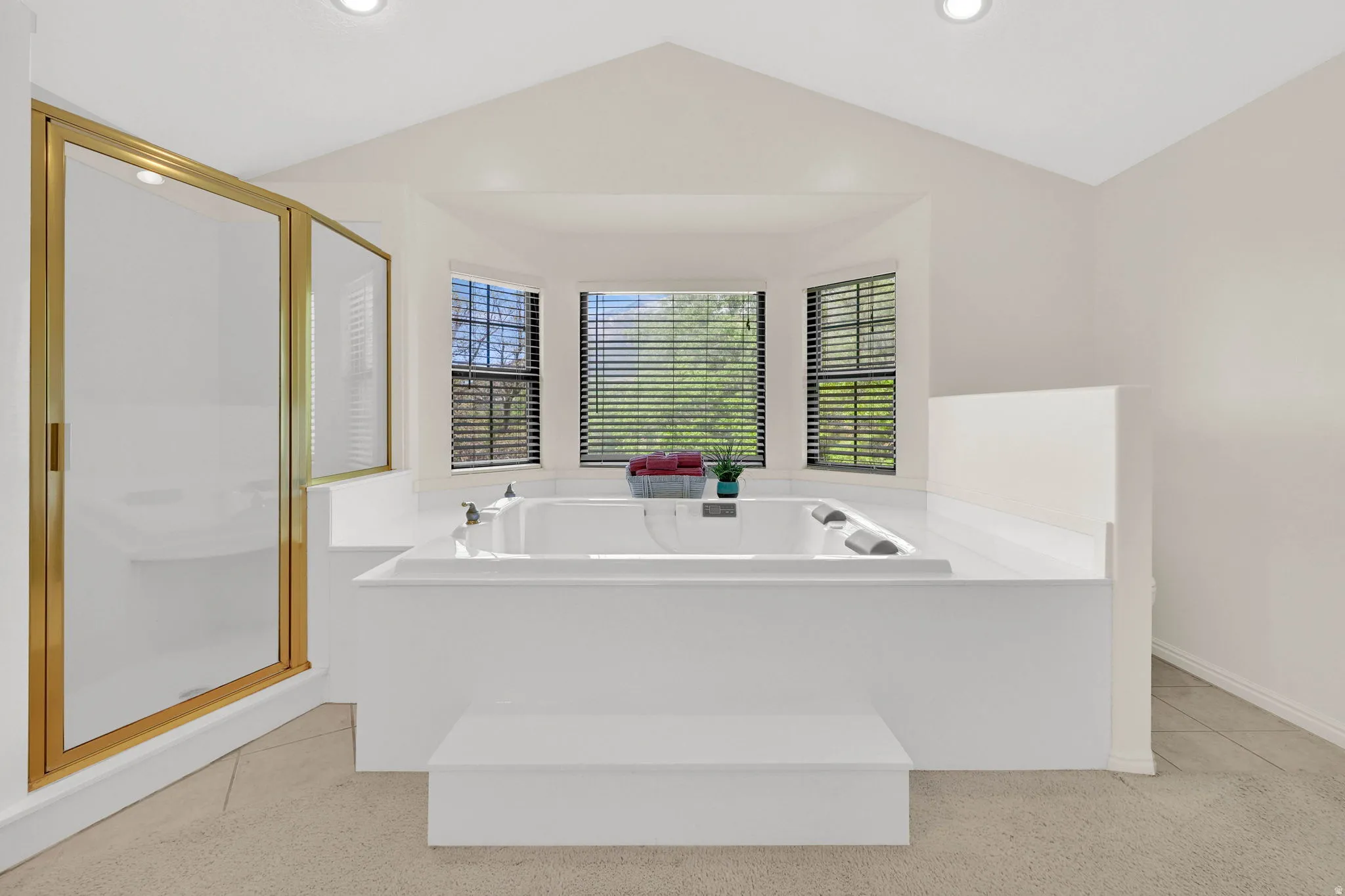 Bathroom with a shower stall, a garden tub, and light tile patterned floors